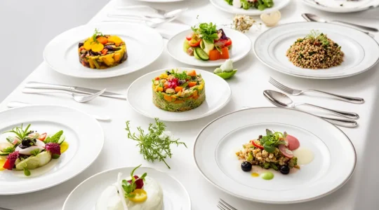 Composition élégante de plats végétaux colorés disposés sur une table de mariage avec fleurs et décoration raffinée